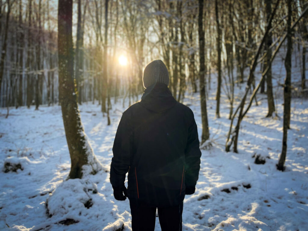 Young man in the forest during winter